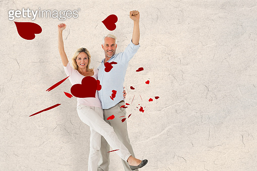 Composite image of smiling couple cheering at the camera (531112517 ...
