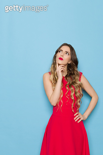 Beautiful Young Woman In Red Dress Is Looking Up And Thinking ...