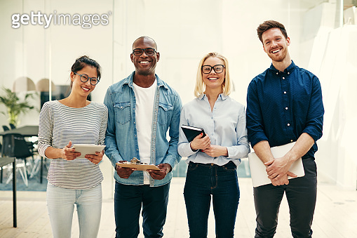 Group of diverse businesspeople laughing together in a modern office ...