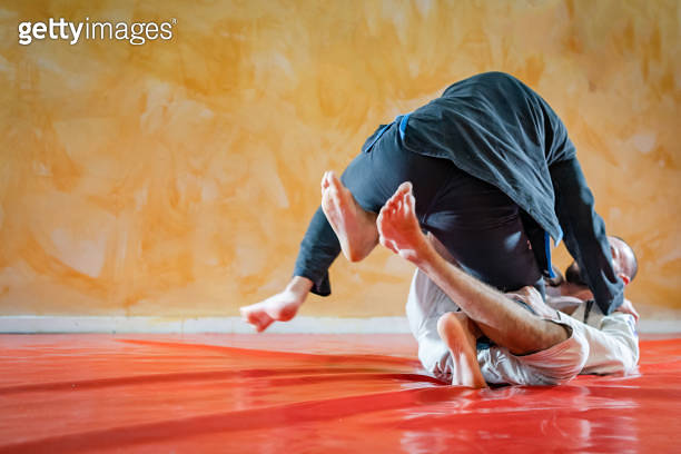 Two brazilian jiu jitsu athletes working on BJJ guard position at the ...