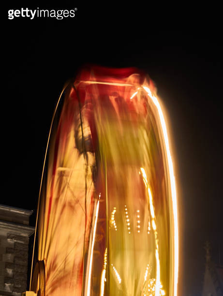 Abstract image of a rotating ferris wheel at night due to motion blur ...
