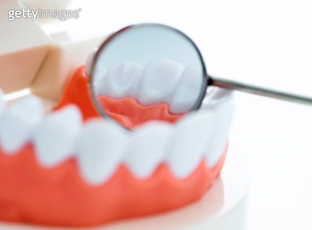 Angled mirror and model teeth on white background (1132258070) - 게티이미지뱅크