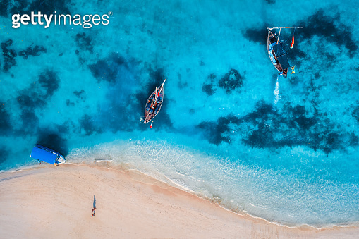 Aerial view of the fishing boats in clear azure water at sunrise in ...