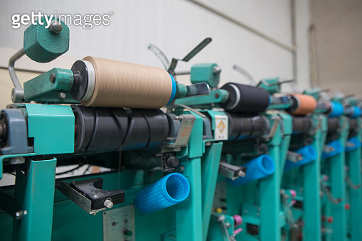 Group of bobbin thread cones on a warping machine in a textile mill ...