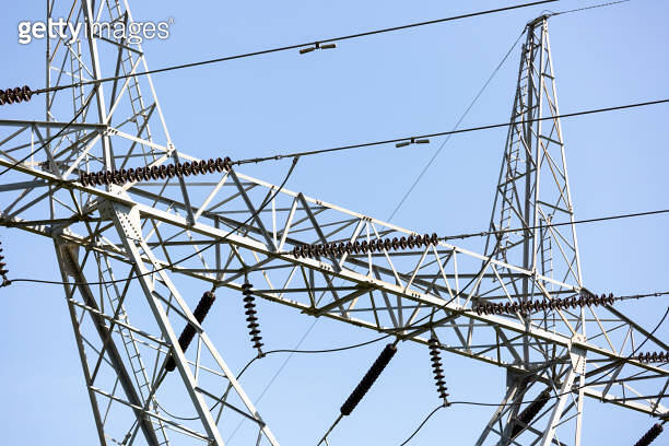 closeup high voltage electricity pylon, blue sky background with copy ...