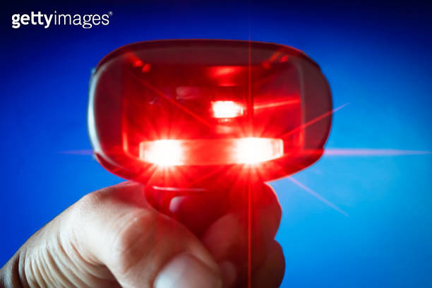 closeup worker hand holding barcode scanner with scanning red laser ...