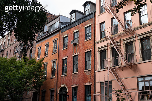 Row of Colorful Old Brick Apartment Buildings with Fire Escapes in ...