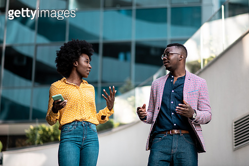 Casual, smart Afro American couple is having discussion in front of a ...