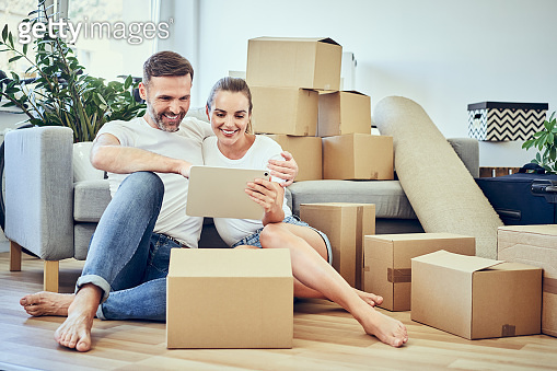 Happy couple using digital tablet while moving to new home (1283726241 ...