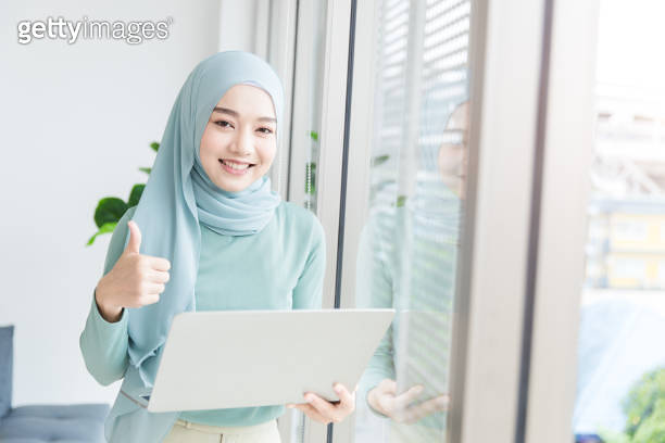 Asian Muslim Islamic woman with hijab happy enjoy working in office ...