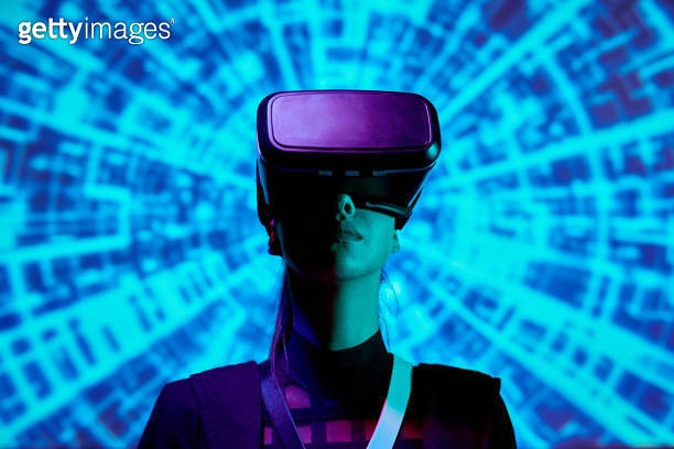 Serious young woman immersed into augmented reality using virtual ...