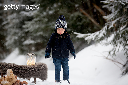 Cute boy playing with teddy bear in the snow, winter time. Little ...
