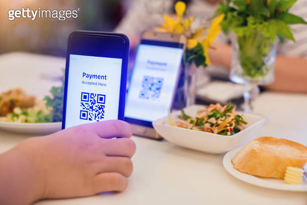 Selective focus to smartphone in hand to scan QR code on tag with ...