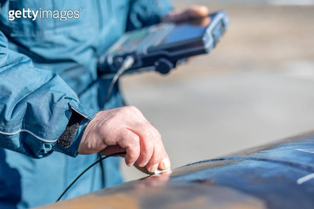 Inspector is checking pipe welds with manual ultrasonic device ...