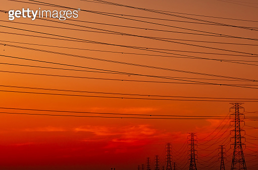 High voltage electric pylon and electrical wire with sunset sky ...