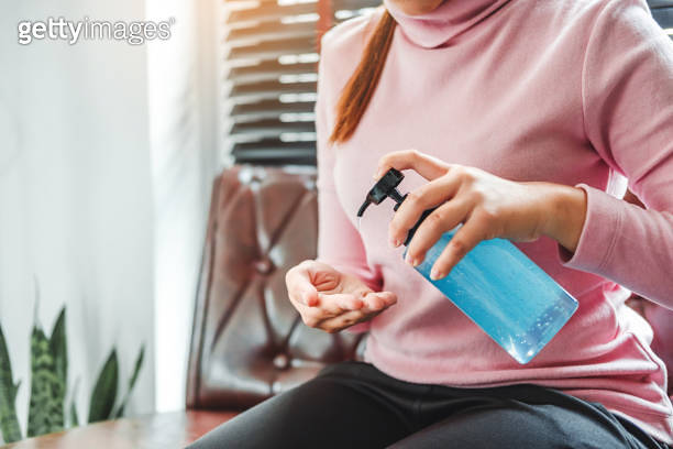 Woman using a hand sanitizer alcohol gel to wash hands to prevent ...