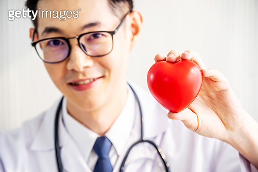 Doctor with stethoscope showing red heart at hospital office, Medical ...