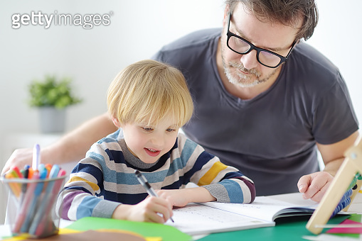 Father helping child do his homework at home. Homeschooling, distance ...