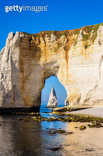 The Needle seen through the arch of the Manneporte cliff in Etretat ...