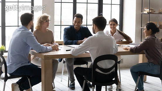 Smiling multiracial employees have fun brainstorming at meeting ...