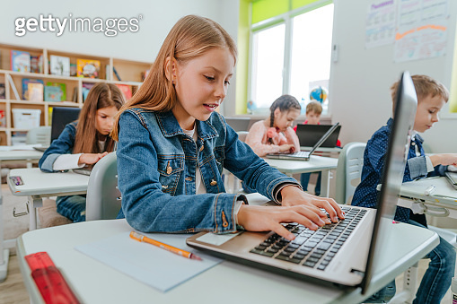 Elementary school students learning in the classroom using laptop ...