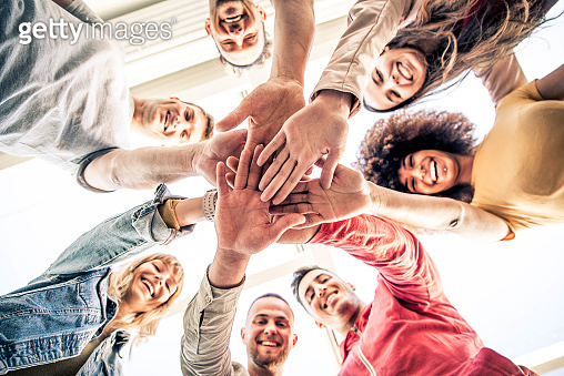 Young happy people stacking hands together outdoor - Community of ...