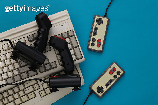 Old keyboard, joysticks and gamepads on blue background. Retro gaming ...
