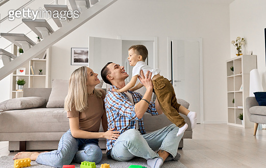 Cheerful young couple having fun with happy cute kid boy relaxing in ...