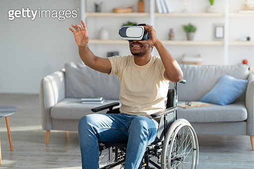 Disabled young black man in wheelchair exploring augmented reality in ...