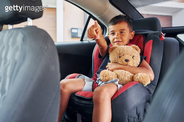 Little boy with teddy bear is sitting in the automobile (1369934057 ...