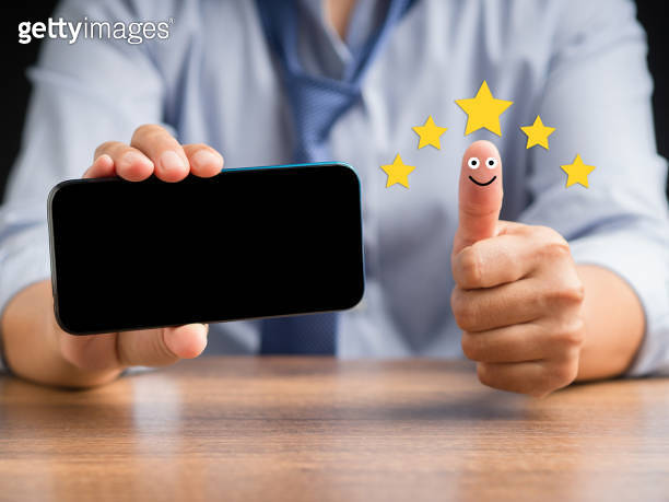 Hand with thumb up for smiley face icon and holding a smartphone ...