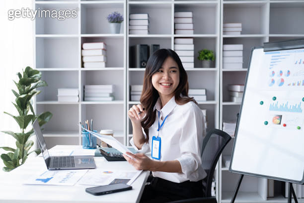 Young Adorable Asian businesswoman working in her modern office room ...