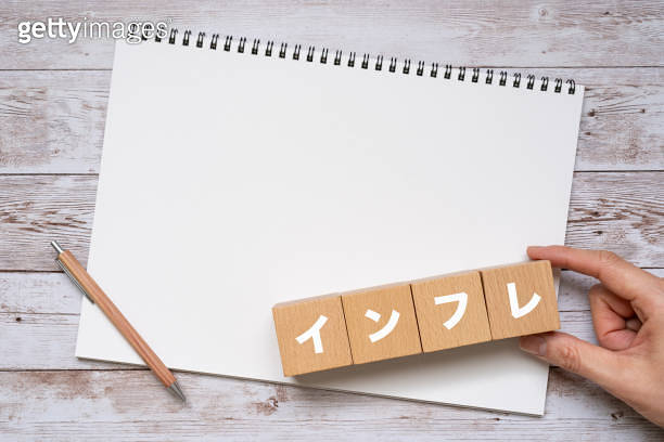 Wooden blocks with "inflation" text of concept, a pen, and a notebook ...