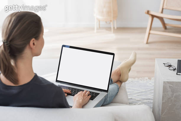 Woman using laptop computer with white blank empty screen mock-up ...
