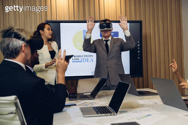 business persons with virtual reality headsets in meeting room at the ...