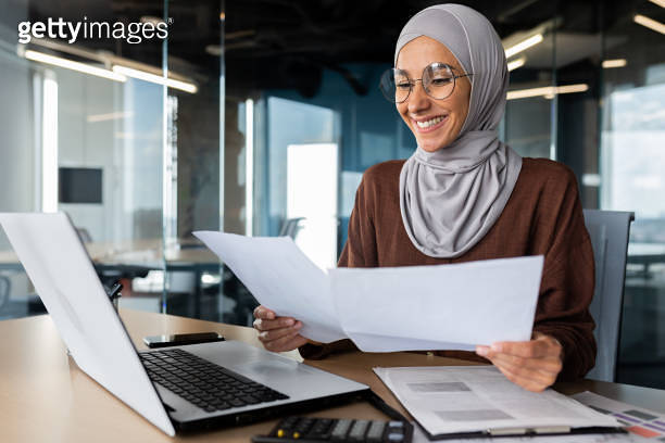 Successful muslim woman in hijab working inside office with documents ...