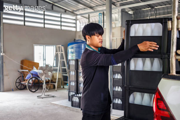 Thai Asian Workers lift white drinking water bottles in crates into the ...