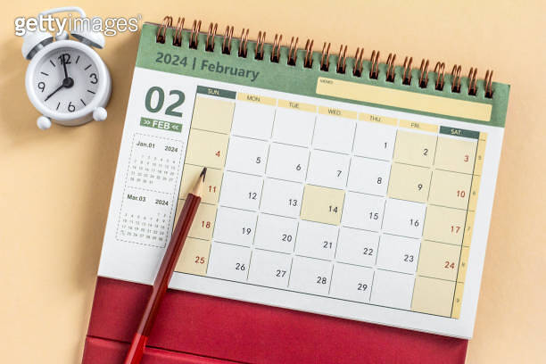 Desk calendar for February 2024 and on the table with copy space ...