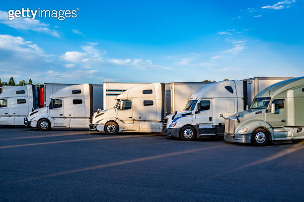 Professional big rig semi trucks with different semi trailers standing ...