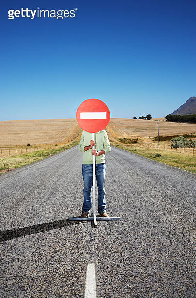 A man holding a sign in the middle of the road 이미지 (77188291) - 게티이미지뱅크