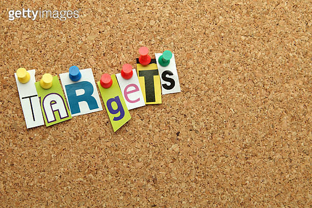 Cutout letters pinned to a notice board spell 'targets' (176123304 ...