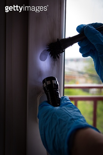 Forensic experts finds fingerprints on the window with the help of ...