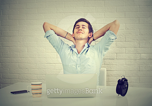 Relaxed Computer User Relaxed young man with laptop computer sitting at his desk 이미지 ...