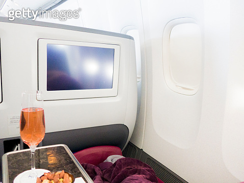 First Class Pink pink champagne and heated nuts in business class cabin, in flight ...