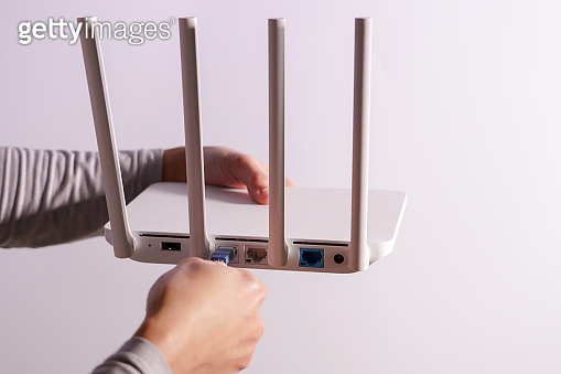 The back view of router showing the lan internet port, and the hand is ...