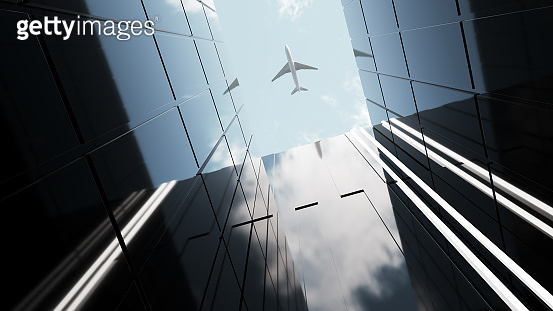 Plane flying over generic modern glass and concrete office buildings ...