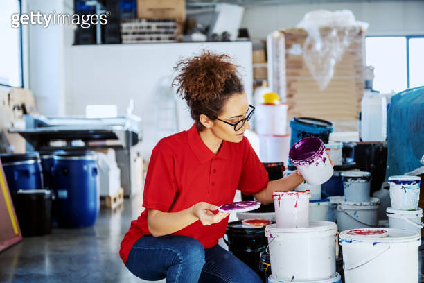 Beautiful caucasian female employee crouching next to buckets with ...