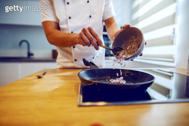 Close up of caucasian creative chef putting onion in saucepan. Saucepan ...