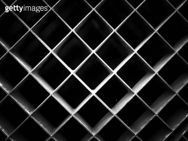 Abstract black and white background pattern of a textured metal grid ...