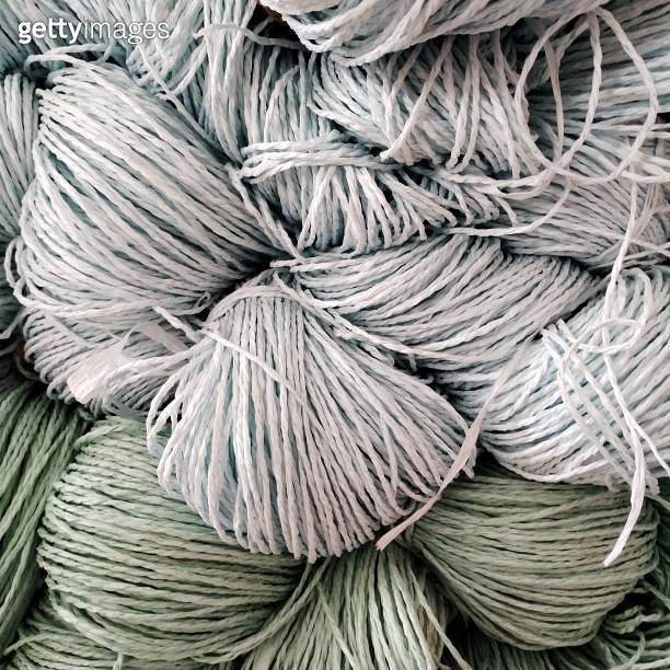 Cascade Raffia Color Some skeins of natural raffia of different colors on shelf. Natural ...